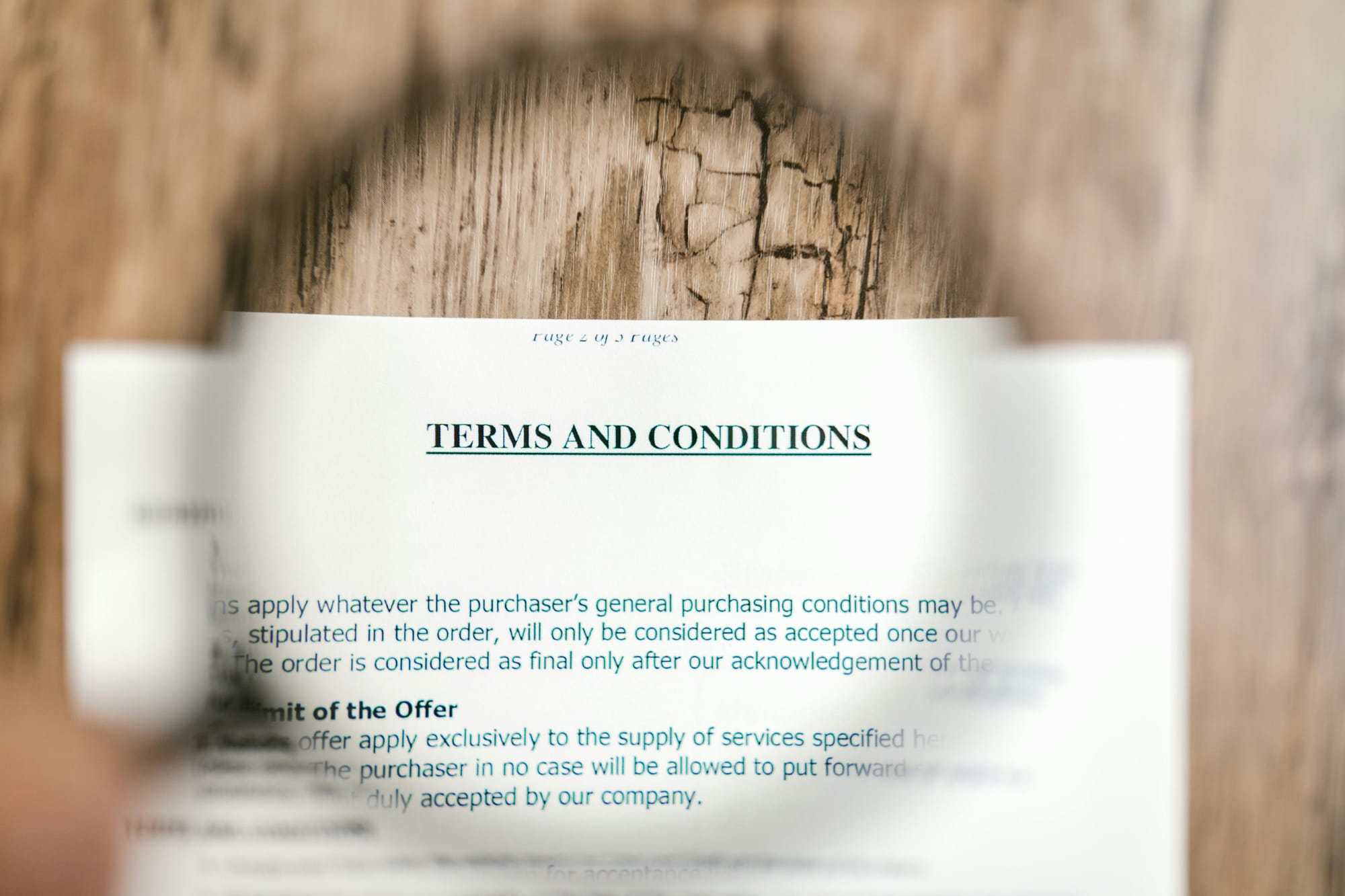 A "Terms and Conditions" page shown underneath a magnifying glass.